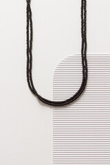 A necklace of black bead on a white background. Top view.