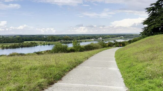 Scenic Pathway Overlooking the Loire River at Chaumont-sur-Loire Estate, with a Tranquil View of the Countryside and Water on a Clear Day