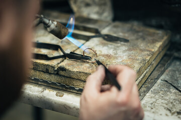 Master soldering jeweller ornament. Picture of hands and product close up.