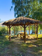 Traditional wooden gazebo overlooking a mountain water body. A great spot for relaxation and solitude in nature.