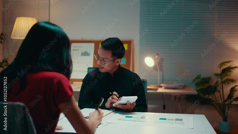 Aufkleber business partners working late in the office, analyzing charts and using a calculator to discuss fin
