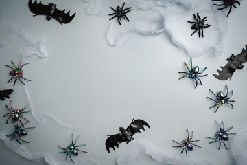 A modern greeting card for Halloween. cobwebs, spiders, bats, a ghost on a fashionable blue background. A banner with a place to copy the text. Top view. Flat Lay.