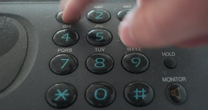 Push buttons on old vintage analog telephone keypad, male hand presses the dial buttons, Dialing process. Number buttons on retro push dial phone. Close-up
