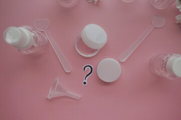 Cosmetic travel kit on pink background, top view. Minimalist body care beauty products for vacation or journey. travel size transparent cosmetic bottles.