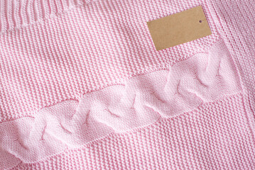 pink knitted plaid for a newborn baby with a tag