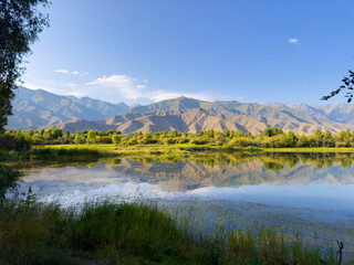 A quiet mountain lake Issyk-Kul, surrounded by green valleys and majestic mountains. The perfect...