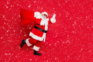 Full length body size view of cheerful cheery dreamy glad funky fat overweight plump gray-haired bearded man piggy backing gifts fairy waving greetings isolated over bright vivid shine red background