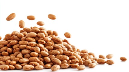 A pile of dried pinto beans with some beans scattered around.