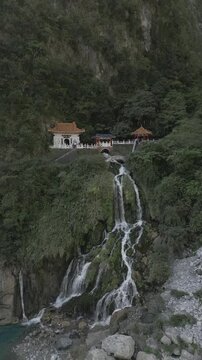 Vertical drone footage of a temple with a waterfall in Taroko Gorge the mountains of Taiwan