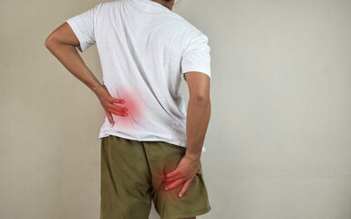 Man feeling nerve pain from lower back and goes down to legs. Sciatica concept