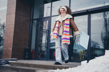 Full body portrait of nice young girl hold mall bags outerwear walk snowy weather city street...