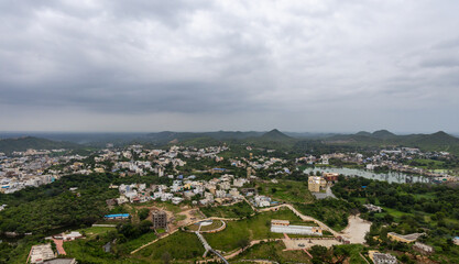 Scenic Aerial Cityscape at Mountain Base Under Cloudy Morning Sky