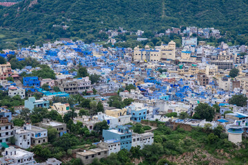 Fototapeta premium Aerial View of Crowded Blue City Houses at Mountain Base in the Evening