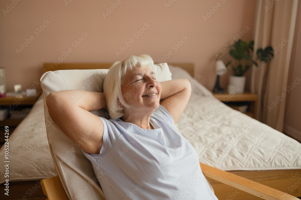 Wall mural calm senior woman relaxing on soft comfortable chair having daytime nap, carefree middle aged female