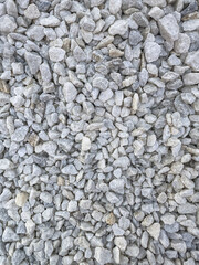 Background of natural gray small pebbles or stone in a garden paths and flower beds.