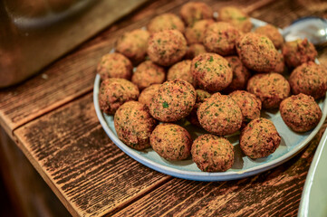 Leckere Falafel-Bällchen und Salat auf einem Teller steht zur Zubereitung von Falafel auf einem Holztisch in der Küche