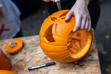 Einen Kürbis mit Messern und Löffel zu Halloween bearbeiten