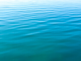 Texture of blue calm water creates a serene and peaceful background. The natural beauty of water reflects the essence of nature, evoking a sense of tranquility reminiscent of the sea.