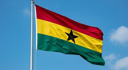 Ghana national flag waving against blue sky with clouds.
