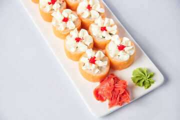 Gourmet salmon sushi rolls served on a black plate with garnishes, ready for a fine dining experience