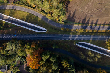 Aerial top down view bike path tunnel underneath motorway. Graphic Dutch infrastructure and transportation concept seen from above. Autumn landscape