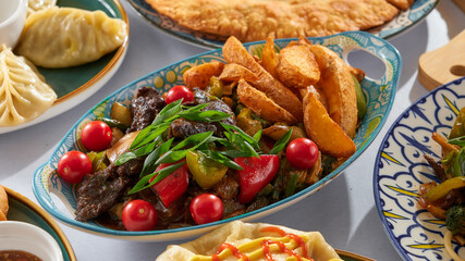 Meat with potatoes and herbs and tomatoes with bell peppers on a white background among other similar Asian dishes