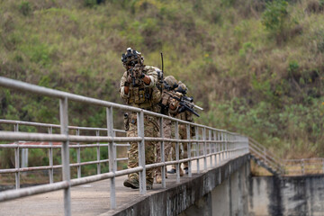 Front view of group of militaries or soldiers with battle suit hold and point gun and walk in the...
