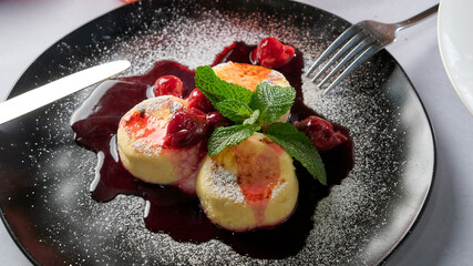 Cottage cheese pancakes with berry jam and mint leaf