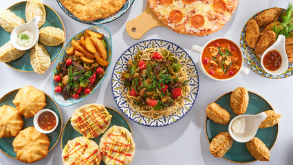 Asian dishes - lagman, manti, meat with potatoes, soup, belyashi on a white background top view
