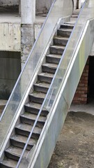 abandoned escalator in an unfinished shopping mall with concrete building walls