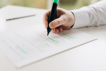 a man uses a marker to highlight important data in a document. indicates errors, editor.