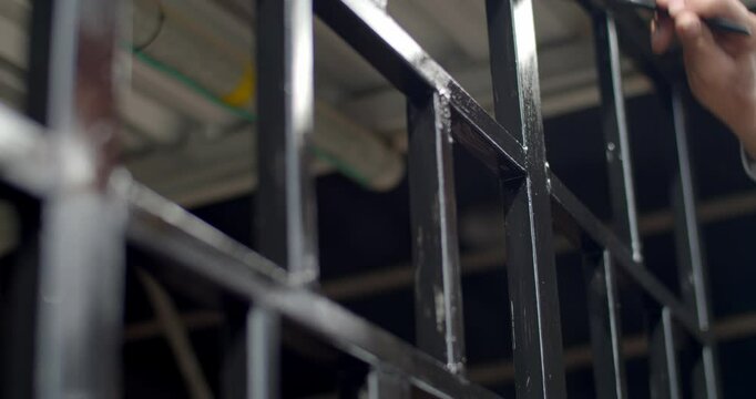 Close up man's hands painting a steel structure.Paint the steel black to prevent rust.Paint brush paint black.