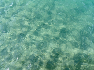 Obraz premium Texture of blue calm water creates a serene and peaceful background. The natural beauty of water reflects the essence of nature, evoking a sense of tranquility reminiscent of the sea.