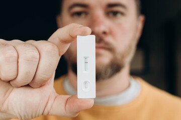 Hand holding negative result of rapid test for covid