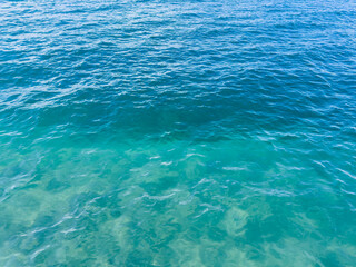 Texture of blue calm water creates a serene and peaceful background. The natural beauty of water reflects the essence of nature, evoking a sense of tranquility reminiscent of the sea.