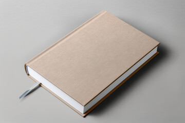 Beige blank hardcover book, notebook, business planner on neutral gray background. Mockup. Top view