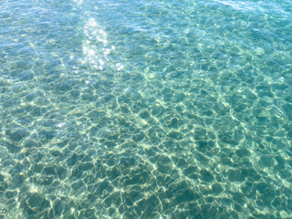 Obraz premium Texture of blue calm water creates a serene and peaceful background. The natural beauty of water reflects the essence of nature, evoking a sense of tranquility reminiscent of the sea.