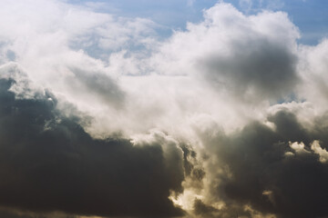 A gap in dense cumulus clouds, cumulus clouds and sun rays break through the veil of clouds.
