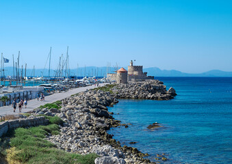 Greece, Rhodes, mole of Mandraki harbour with windmills, views of Saint Nicholas Fortress in background
