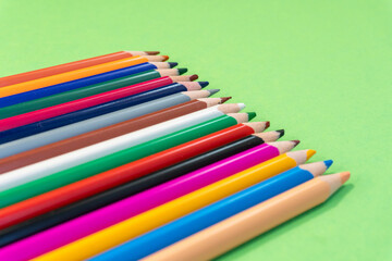 Naklejka premium Many colorful pencils on green background