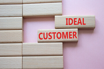 Ideal Customer symbol. Wooden blocks with words Ideal Customer. Beautiful pink background. Business...