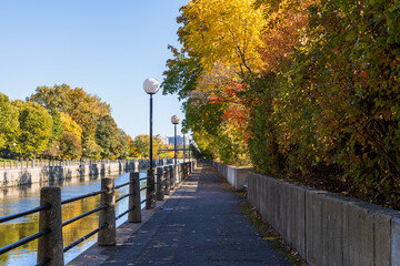 Rideau Canal in Ottawa, Canada during the autumn season, with vibrant fall foliage and a peaceful pathway