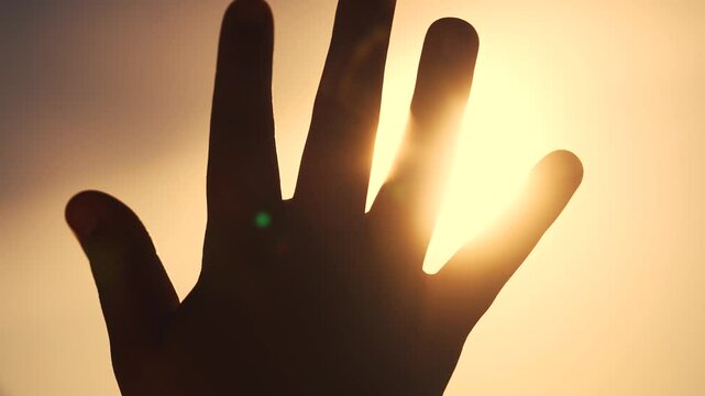 A girl in religion with her hands in the sun. Woman person happy concept. A girl glaring at the sun with her hands. A girl glaring at the sun with her lifestyle hands in religion.