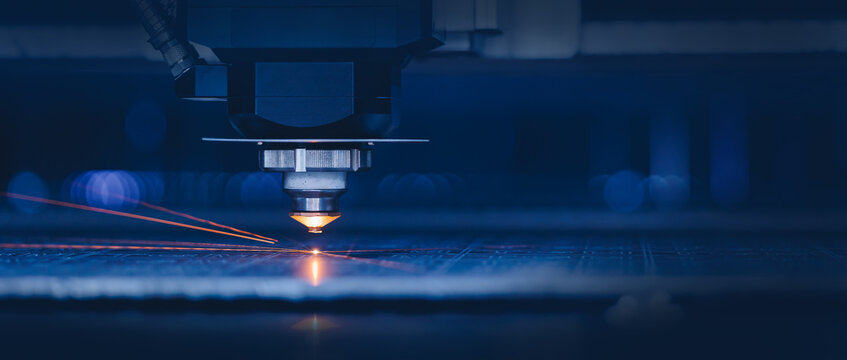 Laser CNC cut of metal with light spark. Blue color background banner, technology modern industrial