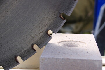 Sägeblatt einer Steinsäge steht an einem Mauerstein an