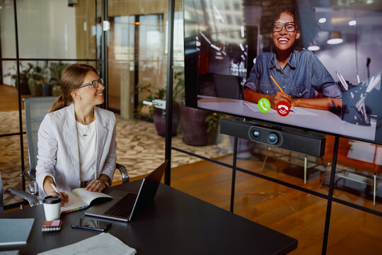 A professional setting that brilliantly showcases a video call between colleagues interacting in a modern workspace