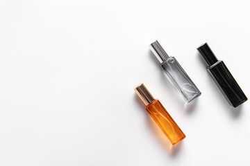 Orange, blue and black glass bottles of perfume on white background. Perfume for man or woman. Free space for text