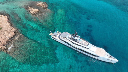 Aerial drone top down photo with copy space of luxury yacht anchored in tropical exotic island with...