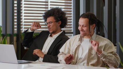 Two African American men businessmen business males guys colleagues in office partnership cooperation win victory celebrate online internet achieve success dancing winning laptop computer good result