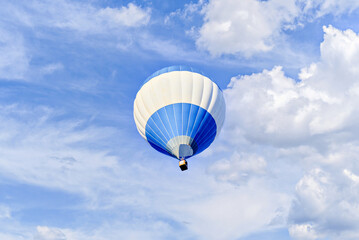 Naklejka premium Colorful hot air balloon flying over blue sky with white clouds 